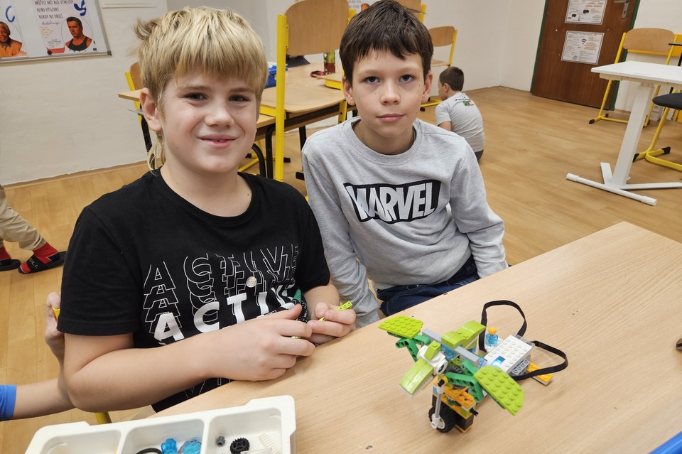 Dvojice devítiletých nad složitějším robotem LEGO WeDo 2.0 s tabletem
